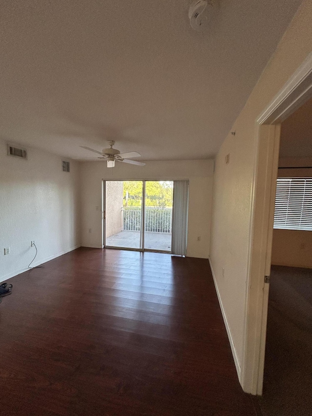 unfurnished room featuring a ceiling fan, visible vents, wood finished floors, and baseboards