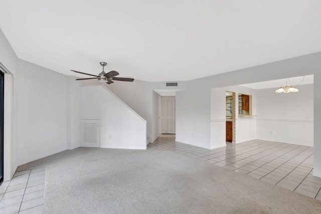 unfurnished living room featuring ceiling fan with notable chandelier and light colored carpet