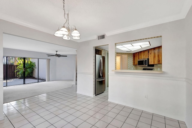 kitchen featuring crown molding, decorative light fixtures, light tile patterned floors, appliances with stainless steel finishes, and ceiling fan with notable chandelier