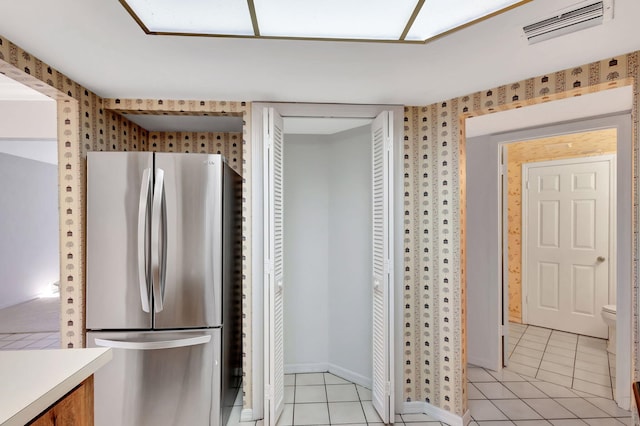 kitchen featuring light tile patterned floors and stainless steel refrigerator