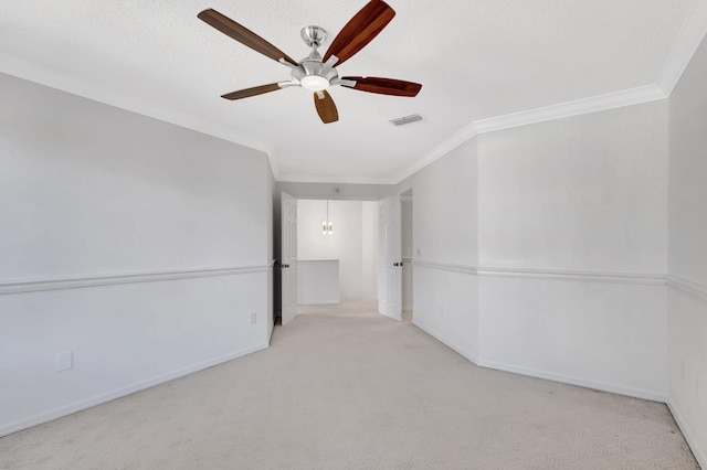 spare room featuring crown molding, light colored carpet, ceiling fan, and a textured ceiling