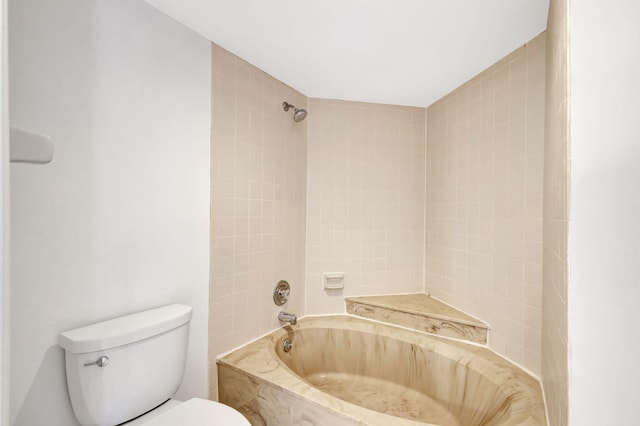 bathroom with tiled shower / bath combo and toilet