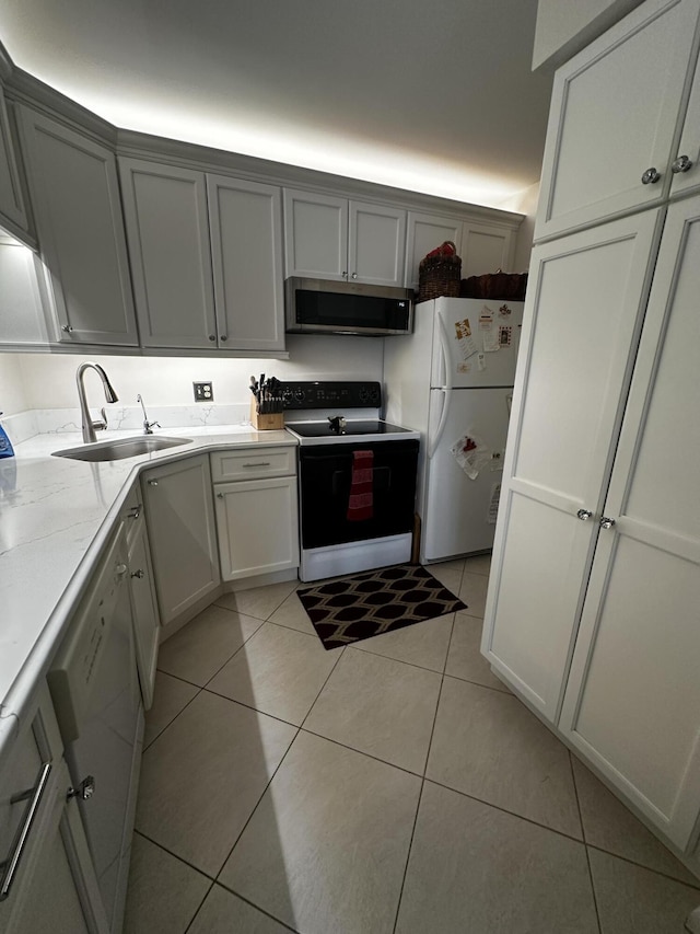 kitchen with white appliances, light tile patterned floors, and sink