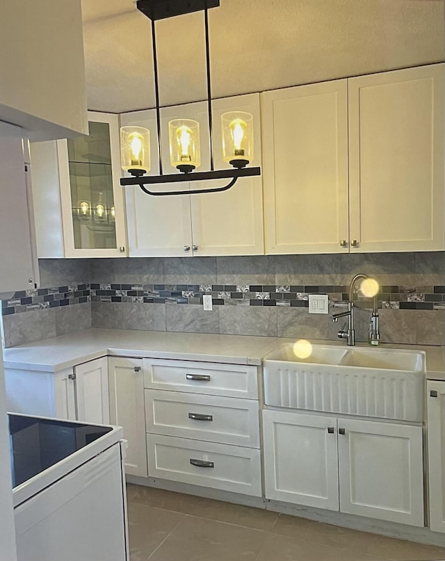 kitchen featuring light tile patterned flooring, tasteful backsplash, white cabinetry, sink, and electric stove