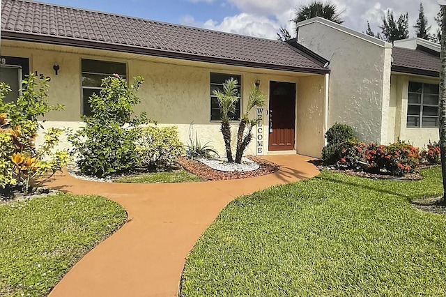 view of exterior entry with a yard