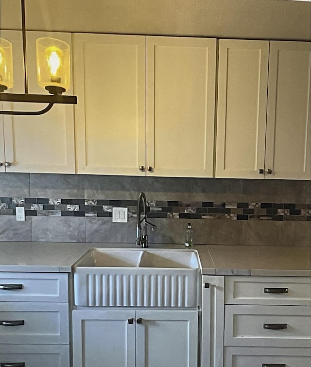 kitchen with white cabinetry, sink, and backsplash