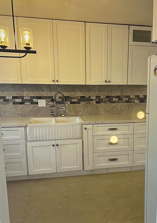 kitchen with white cabinetry, sink, tasteful backsplash, and white fridge