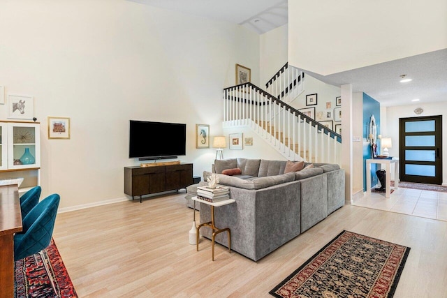 living room with light hardwood / wood-style flooring and a high ceiling