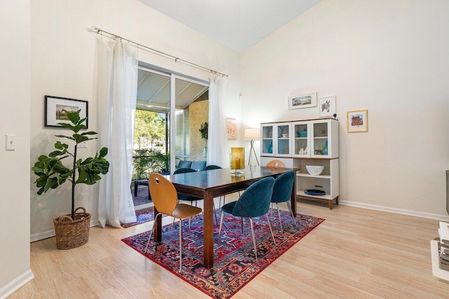 dining space with lofted ceiling and hardwood / wood-style floors