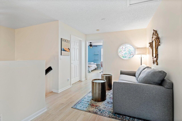 living room featuring light hardwood / wood-style flooring and a textured ceiling