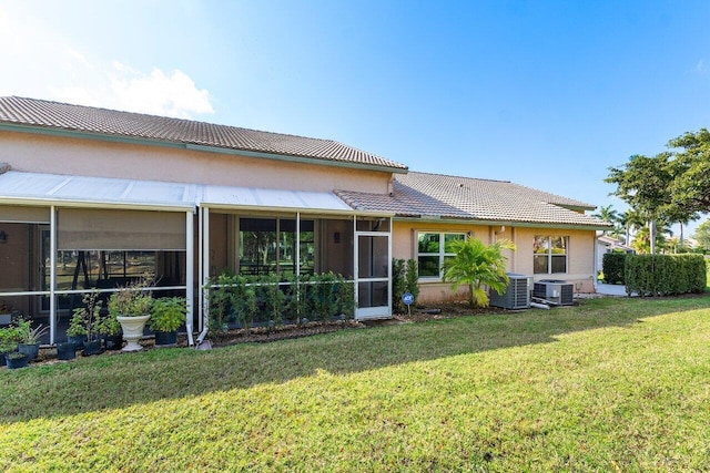 back of house with central AC, a lawn, and a sunroom