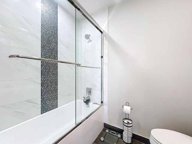 bathroom with shower / bath combination with glass door and toilet