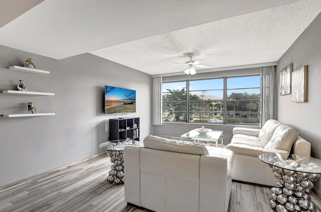 living room with wood-type flooring, a textured ceiling, and ceiling fan