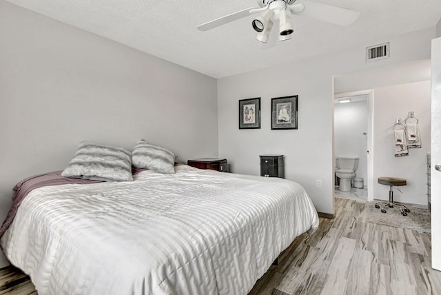 bedroom featuring hardwood / wood-style flooring, ceiling fan, and connected bathroom