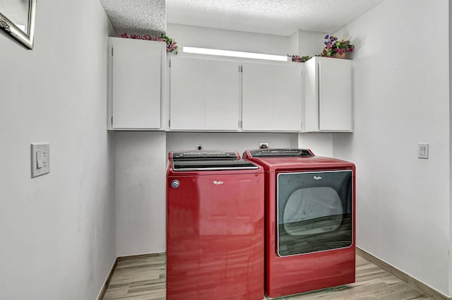 clothes washing area featuring cabinets, a textured ceiling, independent washer and dryer, and light hardwood / wood-style flooring