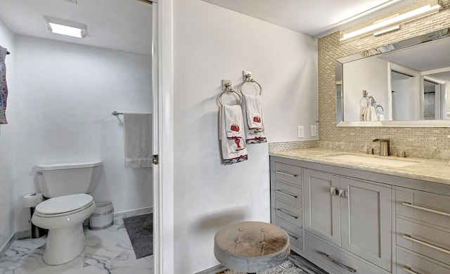 bathroom with vanity, backsplash, and toilet