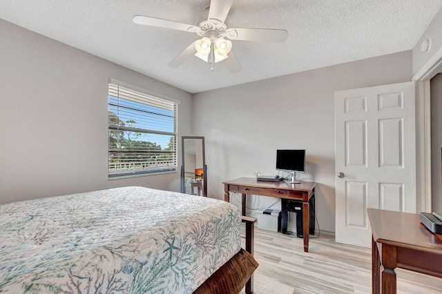 bedroom featuring ceiling fan, a textured ceiling, and light hardwood / wood-style floors