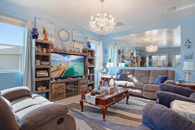 living area featuring a textured ceiling, carpet floors, visible vents, and a notable chandelier