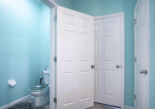 bathroom with toilet and baseboards