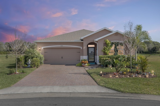 ranch-style house featuring a yard and a garage