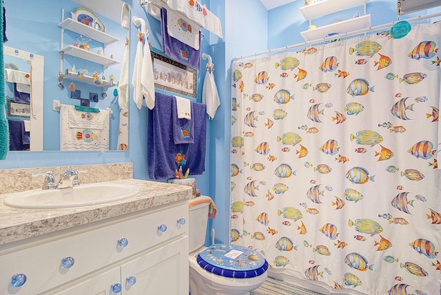 full bathroom featuring a shower with shower curtain, toilet, and vanity