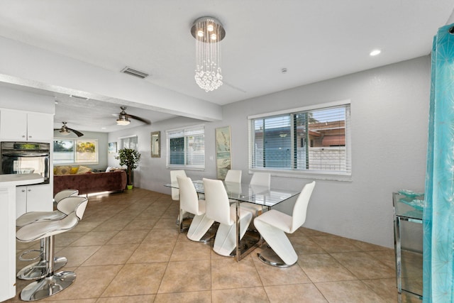 tiled dining space with ceiling fan and a healthy amount of sunlight