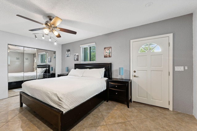 tiled bedroom featuring a textured ceiling, a closet, and ceiling fan