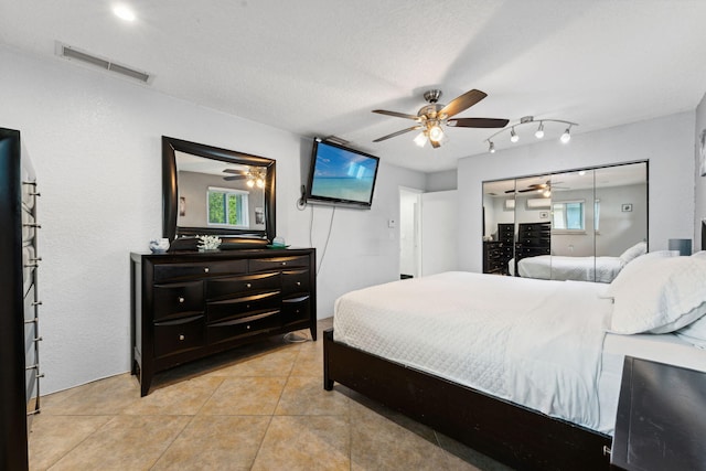 bedroom with light tile patterned floors, a textured ceiling, and ceiling fan