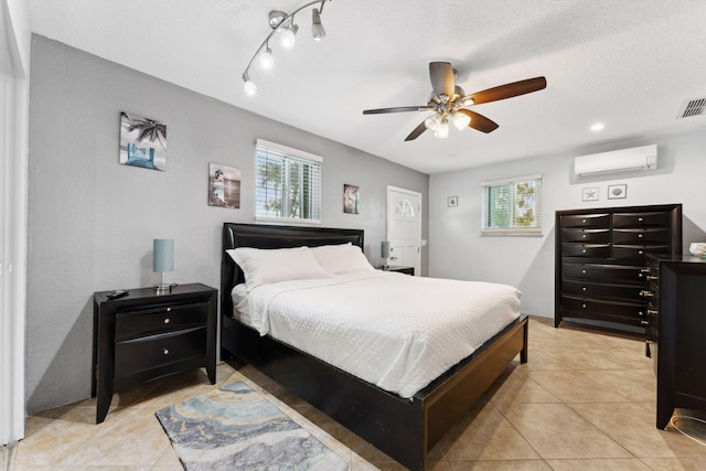 bedroom featuring light tile patterned flooring, multiple windows, ceiling fan, and a wall unit AC