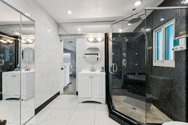 bathroom with tile patterned flooring, vanity, tile walls, and an enclosed shower