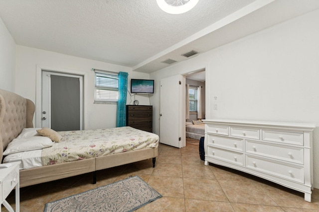 bedroom with light tile patterned flooring and a textured ceiling