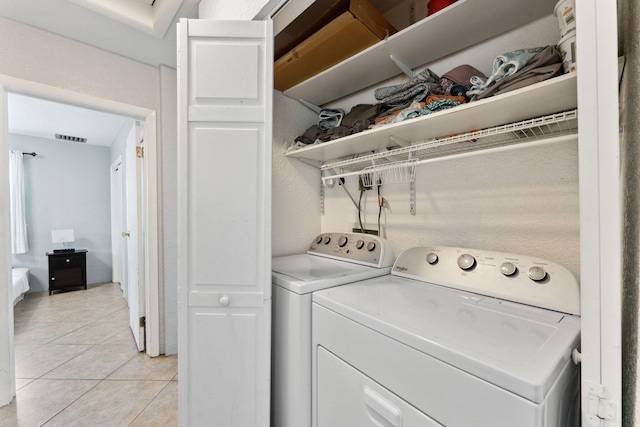 laundry area featuring washing machine and dryer and light tile patterned floors