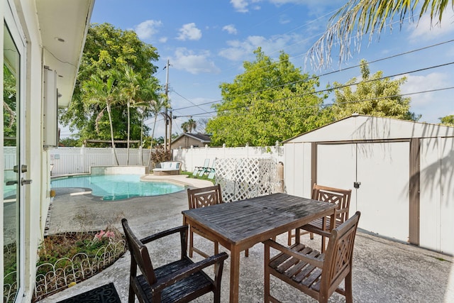 view of patio / terrace with a storage shed and a fenced in pool