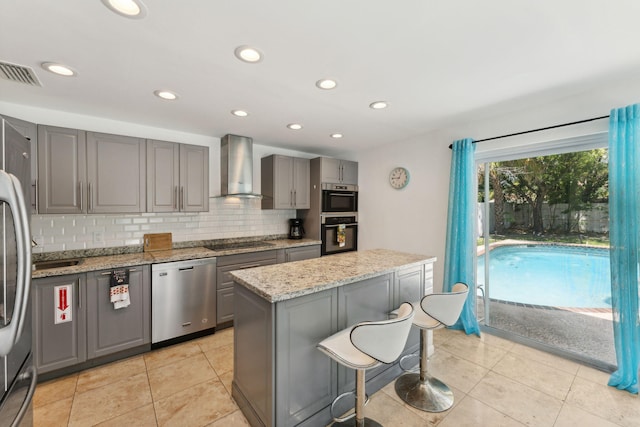 kitchen with wall chimney range hood, dishwasher, a center island, light stone counters, and black electric cooktop