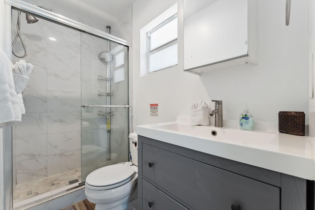 bathroom with vanity, toilet, and a shower with shower door