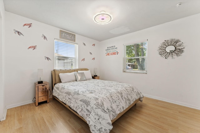 bedroom featuring multiple windows and light hardwood / wood-style flooring