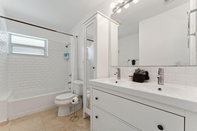 full bathroom with tile patterned floors, toilet, vanity, tiled shower / bath combo, and backsplash