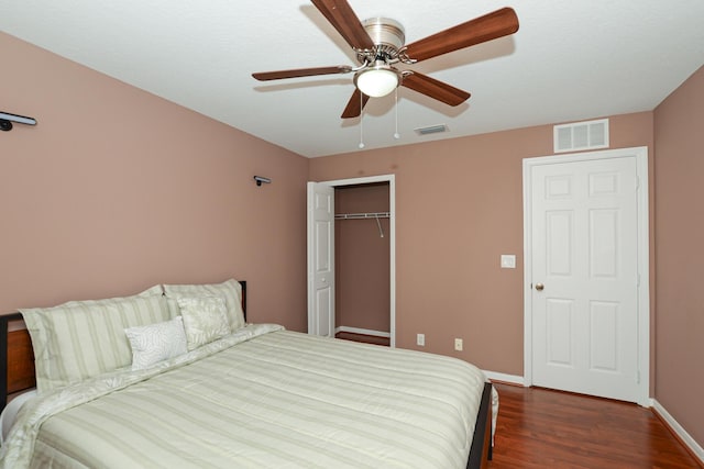 bedroom featuring dark hardwood / wood-style flooring, ceiling fan, and a closet