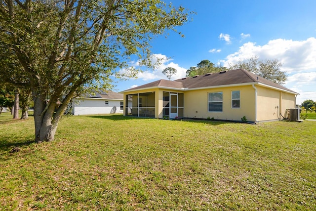 back of property featuring central AC, a sunroom, and a lawn