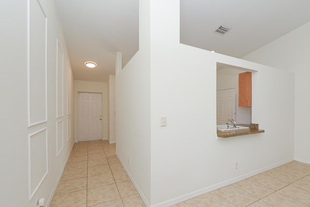 hallway featuring sink and light tile patterned floors