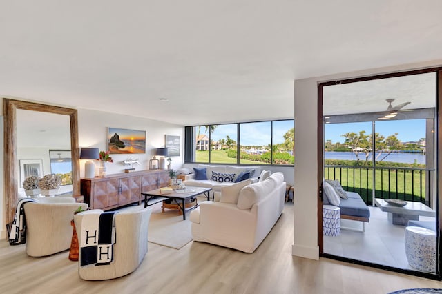 living room with a water view and light hardwood / wood-style flooring