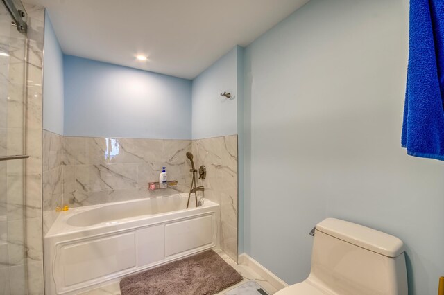 bathroom featuring toilet, tile walls, and a tub