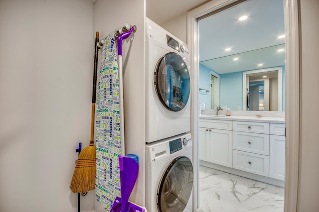 washroom featuring stacked washing maching and dryer and sink