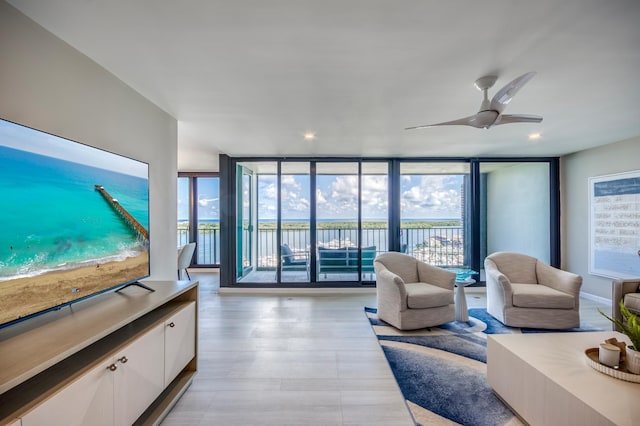 living room with expansive windows and ceiling fan