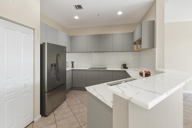 kitchen with gray cabinetry, stainless steel fridge with ice dispenser, sink, and kitchen peninsula