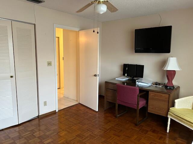 office area featuring dark parquet flooring and ceiling fan