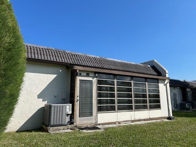 back of house with a yard and central AC unit