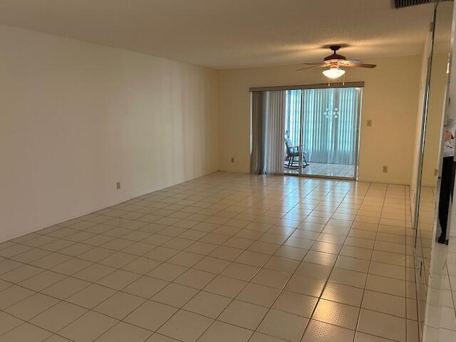 tiled empty room with ceiling fan