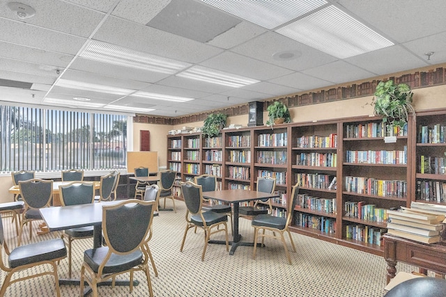 carpeted dining room with a drop ceiling