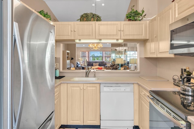 kitchen with an inviting chandelier, sink, and appliances with stainless steel finishes